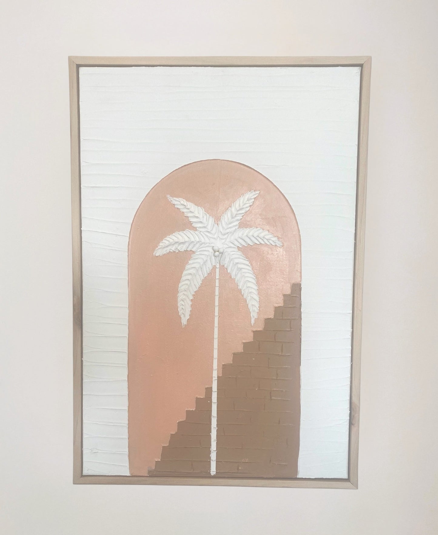 Framed textured artwork with a palm tree design on a pink and brown background.