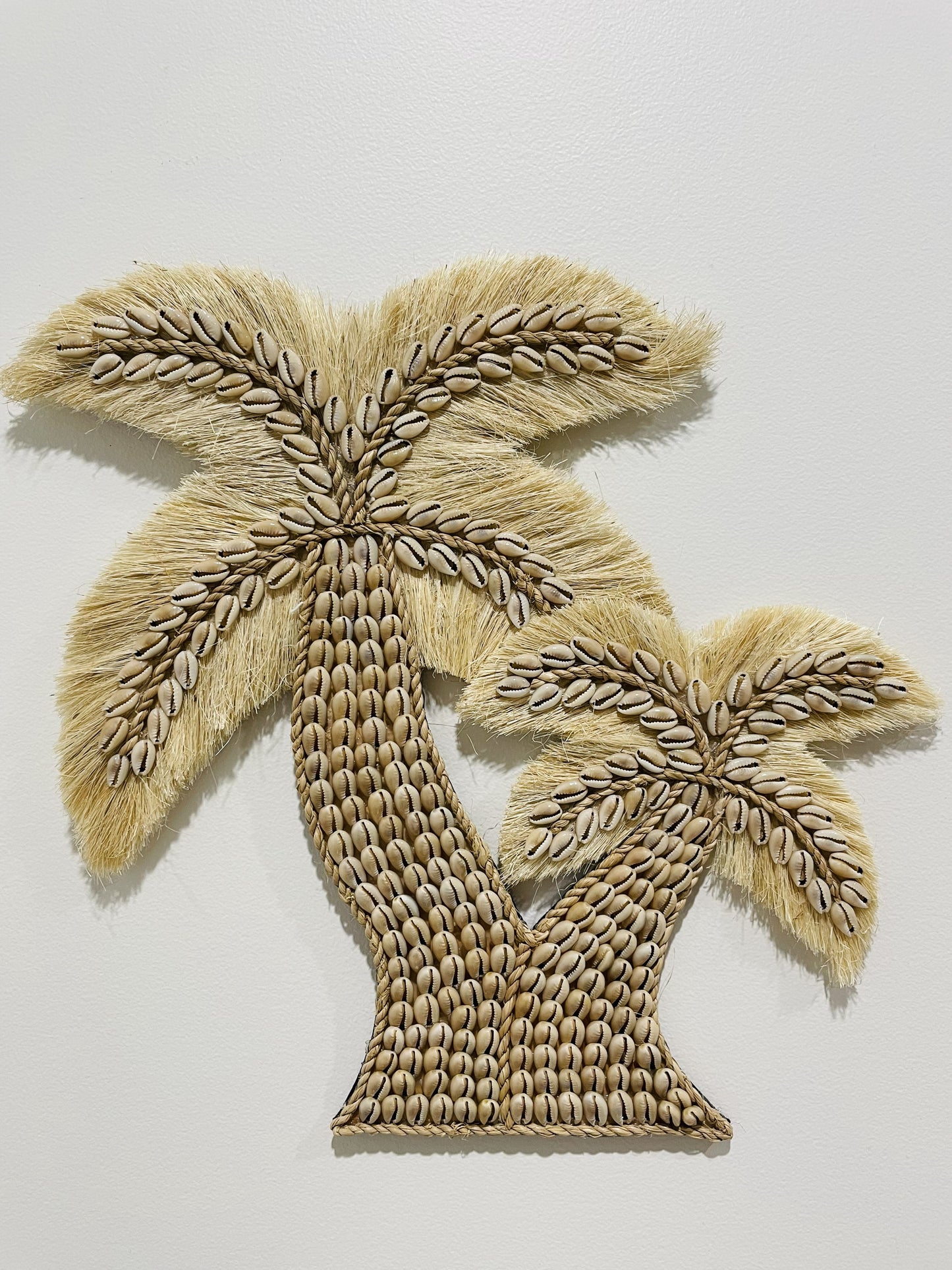 Beige twin cowrie shell palm tree wall art on a white background