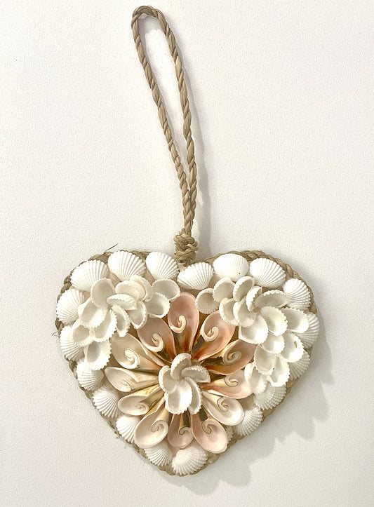 Heart-shaped decorative wall hanging made of seashells with a rope handle on a white background