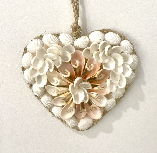 Heart-shaped decorative pendant made of seashells on a white background