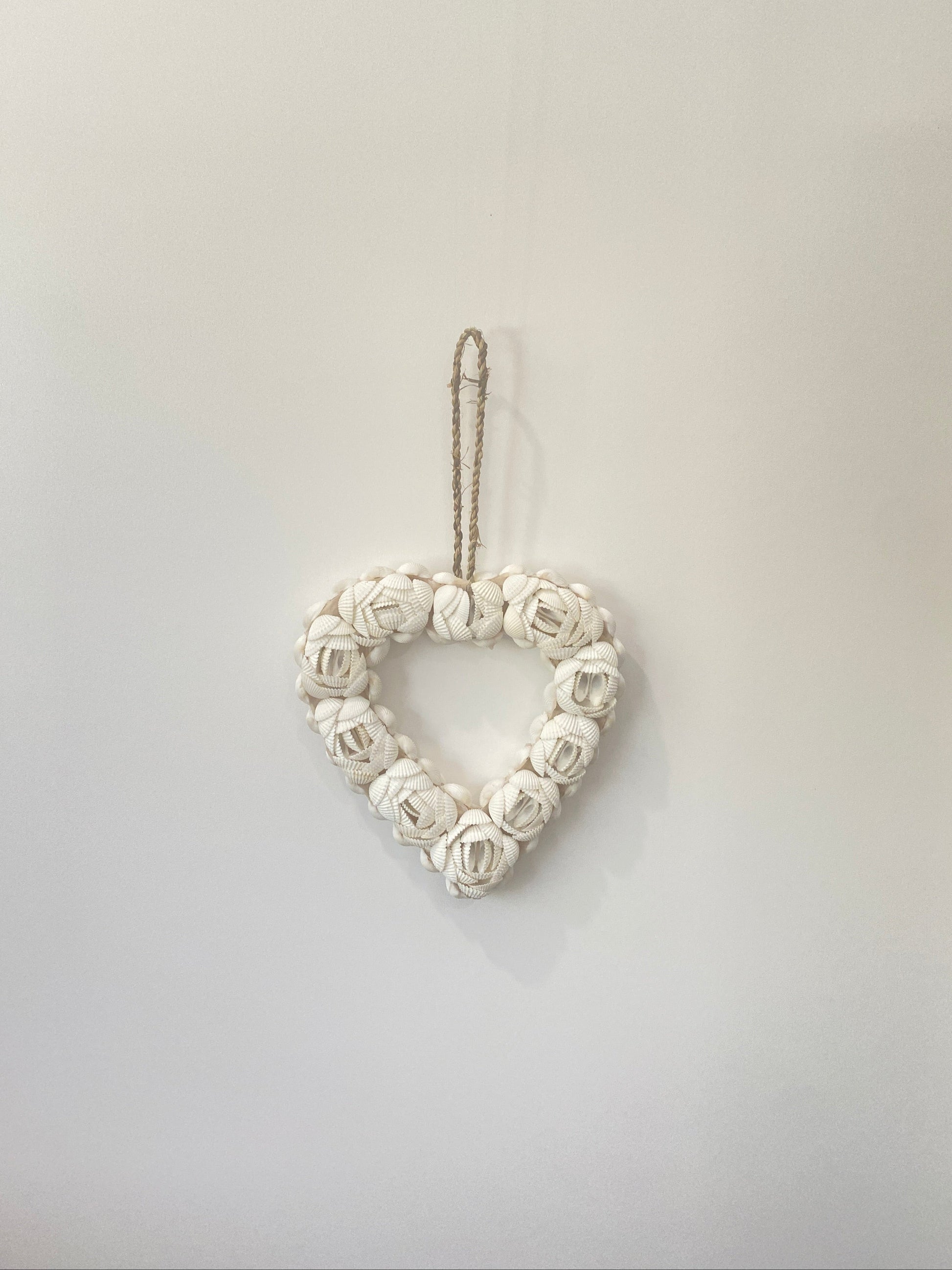 White shell love heart wall art pendant on a light gray background