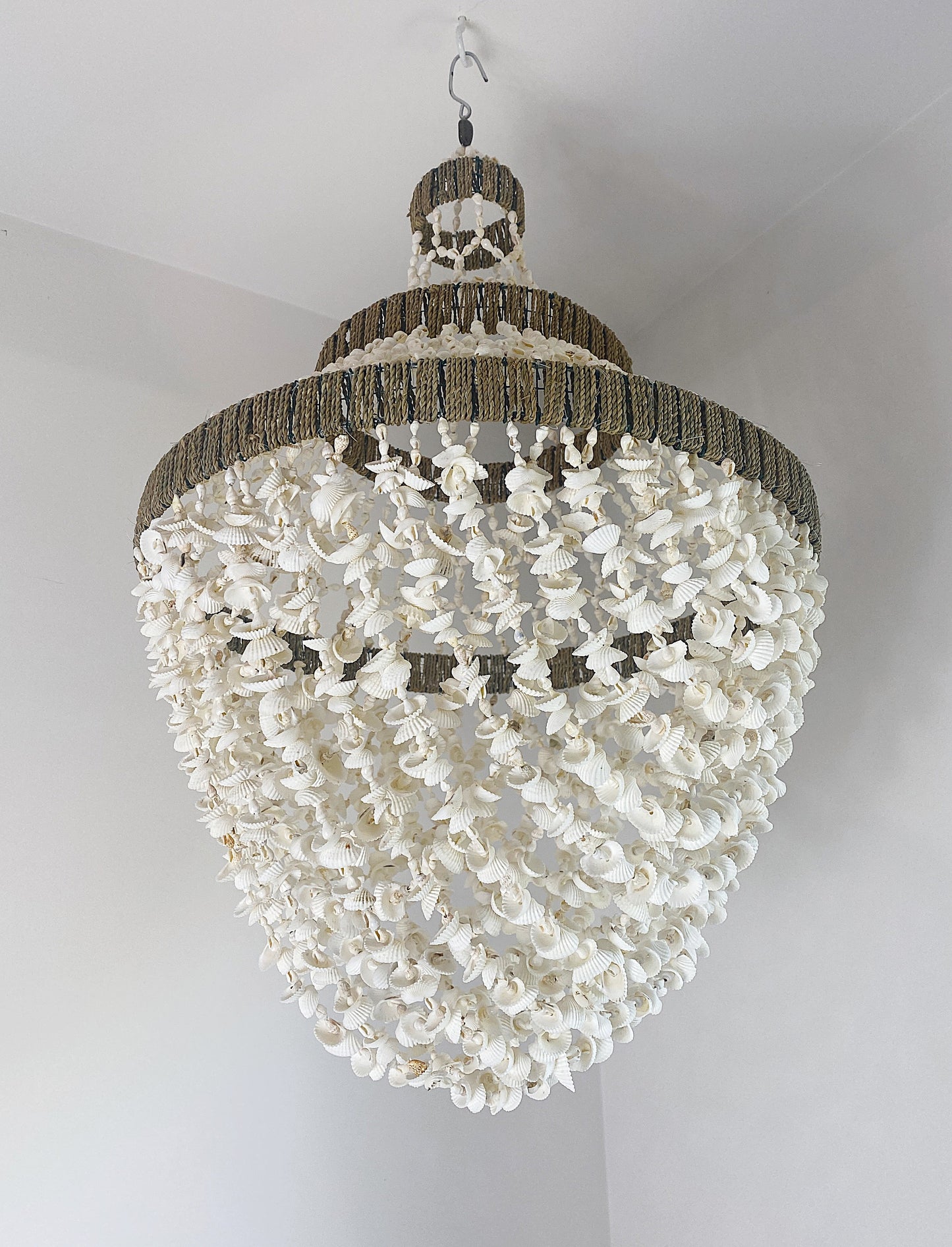 Teardrop shaped handmade shell chandelier with looped shell strands to form an egg shape