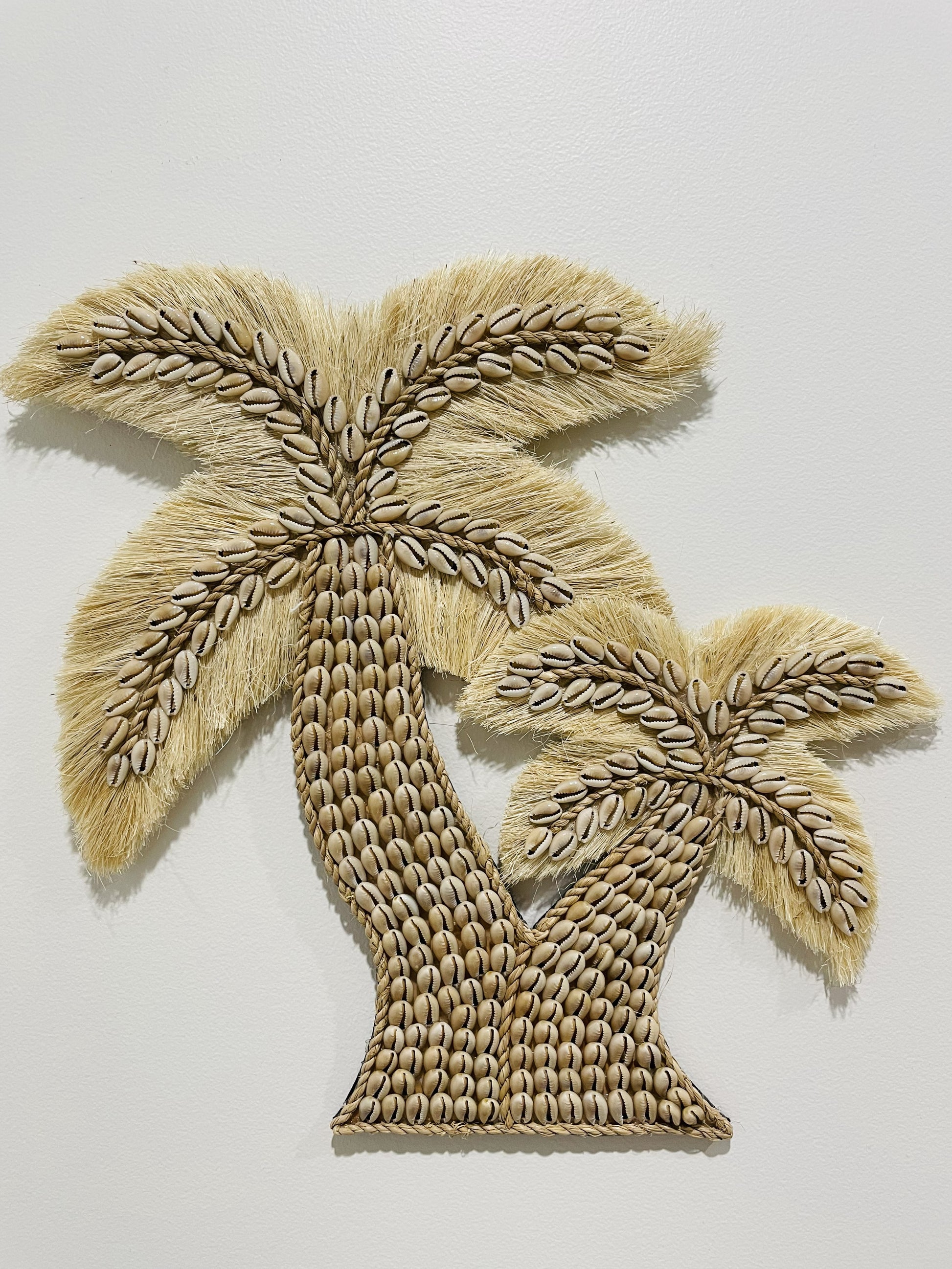 Beige twin cowrie shell palm tree wall art on a white background