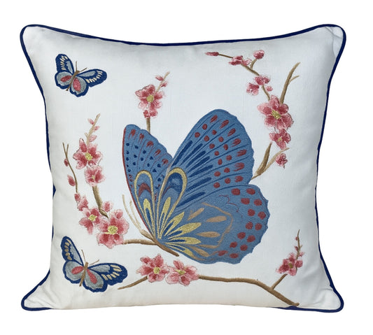 Decorative pillow with embroidered butterflies and flowers on a white background
